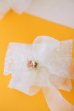 Μπομπονιέρα γάμου ιβουάρ δαντέλα με φιόγκο και τριαντάφυλλο σομόν
